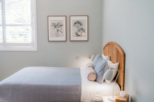 Bedroom with a queen bed, wooden headboard, and framed pictures on the wall.